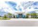 Beautiful clubhouse with blue accents, palm trees, and a grand entrance at 9982 Beachwalk Dr, Englewood, FL 34223
