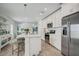 Bright kitchen boasts white cabinets, stainless steel appliances, and an island with seating at 1352 Sunset Preserve Way, Port Charlotte, FL 33953