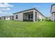 View of a screened patio with a grassy backyard at 1352 Sunset Preserve Way, Port Charlotte, FL 33953