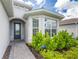 Inviting home exterior with a gray front door and lush landscaping at 9982 Beachwalk Dr, Englewood, FL 34223