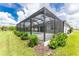 Screened pool and patio with lush landscaping at 9982 Beachwalk Dr, Englewood, FL 34223