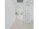 Hallway view of the home's interior showcasing tile flooring and a glass door at 9982 Beachwalk Dr, Englewood, FL 34223