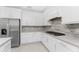 Modern kitchen features white cabinets, stainless steel appliances, and gray countertops at 9982 Beachwalk Dr, Englewood, FL 34223