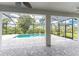 Covered patio with pool and lush landscaping at 9982 Beachwalk Dr, Englewood, FL 34223