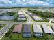 Aerial view of a residential neighborhood with houses and a lake at 9982 Beachwalk Dr, Englewood, FL 34223