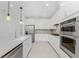 Modern kitchen with white cabinets, stainless steel appliances and an island at 9982 Beachwalk Dr, Englewood, FL 34223
