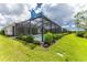 Screened pool and patio with lush landscaping at 9982 Beachwalk Dr, Englewood, FL 34223