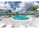 Relaxing pool area with plenty of lounge chairs and palm trees at 9982 Beachwalk Dr, Englewood, FL 34223