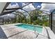 Enclosed pool area with paver deck and a metal handrail at 9982 Beachwalk Dr, Englewood, FL 34223