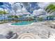 Expansive pool area with lounge chairs, palm trees, and a waterfall feature at 9982 Beachwalk Dr, Englewood, FL 34223