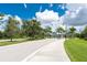 Landscaped entrance to community with paved road and sidewalk at 9982 Beachwalk Dr, Englewood, FL 34223
