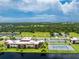 Aerial view showcasing condo building near waterway and tennis courts at 66 Boundary Blvd # 238, Rotonda West, FL 33947