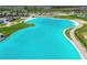 Aerial view of a crystal-clear lagoon with surrounding green space at 7537 Pool Compass Loop, Wesley Chapel, FL 33545