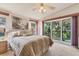 Main bedroom with garden views and ceiling fan at 816 Manchester Ct, Englewood, FL 34223