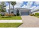 Single-story house with gray siding, two-car garage and landscaped yard at 14589 Ponce De Leon Trl, Port Charlotte, FL 33981