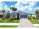 New gray home with a tile roof, two-car garage, and lush landscaping, located on a quiet street at 14589 Ponce De Leon Trl, Port Charlotte, FL 33981