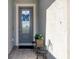 Front entry with gray door, potted plants, and a decorative chair at 14589 Ponce De Leon Trl, Port Charlotte, FL 33981