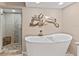 Spa-like bathroom featuring a soaking tub, decorative octopus art, and a glass-enclosed shower at 11000 Placida Rd # 2303, Placida, FL 33946