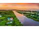 Aerial view of waterfront property at sunset with lush landscaping, pools, and river access at 11160 Hacienda Del Mar Blvd # D-205, Placida, FL 33946