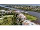 Aerial view of condo community with lush landscaping and river access; speedboat on waterway at 11160 Hacienda Del Mar Blvd # D-205, Placida, FL 33946