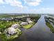 Aerial view of waterfront condo community with lush landscaping and river access at 11160 Hacienda Del Mar Blvd # D-205, Placida, FL 33946