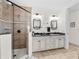 Bright bathroom features a stand-up shower, white cabinets, black hardware, and dual vanity sinks at 11160 Hacienda Del Mar Blvd # D-205, Placida, FL 33946
