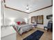 Bedroom with wood trim, tile floor, ceiling fan, and abundant natural light from windows with shutters at 11160 Hacienda Del Mar Blvd # D-205, Placida, FL 33946