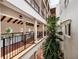 Hallway with terracotta floors, pillars, and black iron railings overlooking courtyard with tropical foliage at 11160 Hacienda Del Mar Blvd # D-205, Placida, FL 33946