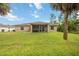 Home features a large backyard with a screened patio and lush grass at 3288 Myrica St, North Port, FL 34286