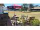 Outdoor patio with comfortable seating, an umbrella-covered table, and lush lawn area at 6367 Facet Ln, Port Charlotte, FL 33981