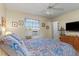 This bedroom features a window, ceiling fan, and a television set atop a wooden dresser at 6367 Facet Ln, Port Charlotte, FL 33981