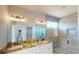 Modern bathroom with dual sinks, granite counters, stylish fixtures, and a glass enclosed walk-in shower at 721 Redbud Ct, Englewood, FL 34223