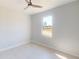 Neutral bedroom features a ceiling fan and a large window offering views of the surrounding landscape at 721 Redbud Ct, Englewood, FL 34223