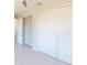 Bright bedroom features a closet with white bi-fold doors and light colored flooring at 721 Redbud Ct, Englewood, FL 34223