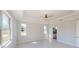 A bright bedroom with tile floor, a ceiling fan and tray ceilings, and natural light from multiple windows at 721 Redbud Ct, Englewood, FL 34223