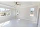 A bright bedroom with tile floor, a ceiling fan and tray ceilings, and natural light from multiple windows at 721 Redbud Ct, Englewood, FL 34223