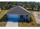Aerial view of a single-story home with a two-car garage, well-manicured lawn, and mature trees at 721 Redbud Ct, Englewood, FL 34223
