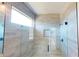 This bathroom has a glass enclosed walk-in shower with stone-look tile and a rainfall shower head at 721 Redbud Ct, Englewood, FL 34223