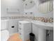 Bathroom featuring a toilet, sink, accent tile, and built in cabinet with a round mirror at 8 Quails Run Blvd # 10, Englewood, FL 34223