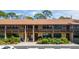 Two-story condo building with private balconies, well-maintained landscaping, and dedicated parking at 8 Quails Run Blvd # 10, Englewood, FL 34223