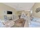 Bright living room featuring comfortable sofas, a coffee table, and a large TV at 3413 Pennyroyal Rd, Port Charlotte, FL 33953