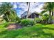 Landscaped backyard with a screened porch and lake view at 3413 Pennyroyal Rd, Port Charlotte, FL 33953