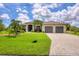 Single-story house with two-car garage and palm trees at 15608 Lakeland Cir, Port Charlotte, FL 33981