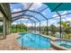 Enclosed pool and spa overlooking a canal with lush landscaping at 15608 Lakeland Cir, Port Charlotte, FL 33981