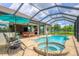 Relaxing pool and spa area with screened enclosure and patio furniture at 15608 Lakeland Cir, Port Charlotte, FL 33981
