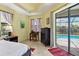 Bright bedroom with pool view, showcasing a king-size bed and convenient workspace at 15608 Lakeland Cir, Port Charlotte, FL 33981