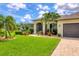 One-story home with a landscaped front yard and a gray garage door at 15608 Lakeland Cir, Port Charlotte, FL 33981