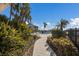 Stone pathway leads to a refreshing pool surrounded by tropical plants at 11000 Placida Rd # 2303, Placida, FL 33946