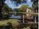 Serene lakefront view with a park bench, lush landscaping, and peaceful atmosphere at 8 Quails Run Blvd # 10, Englewood, FL 34223