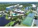 Aerial view of community with pool, tennis courts, and pond at 8413 Placida Rd # 407, Placida, FL 33946